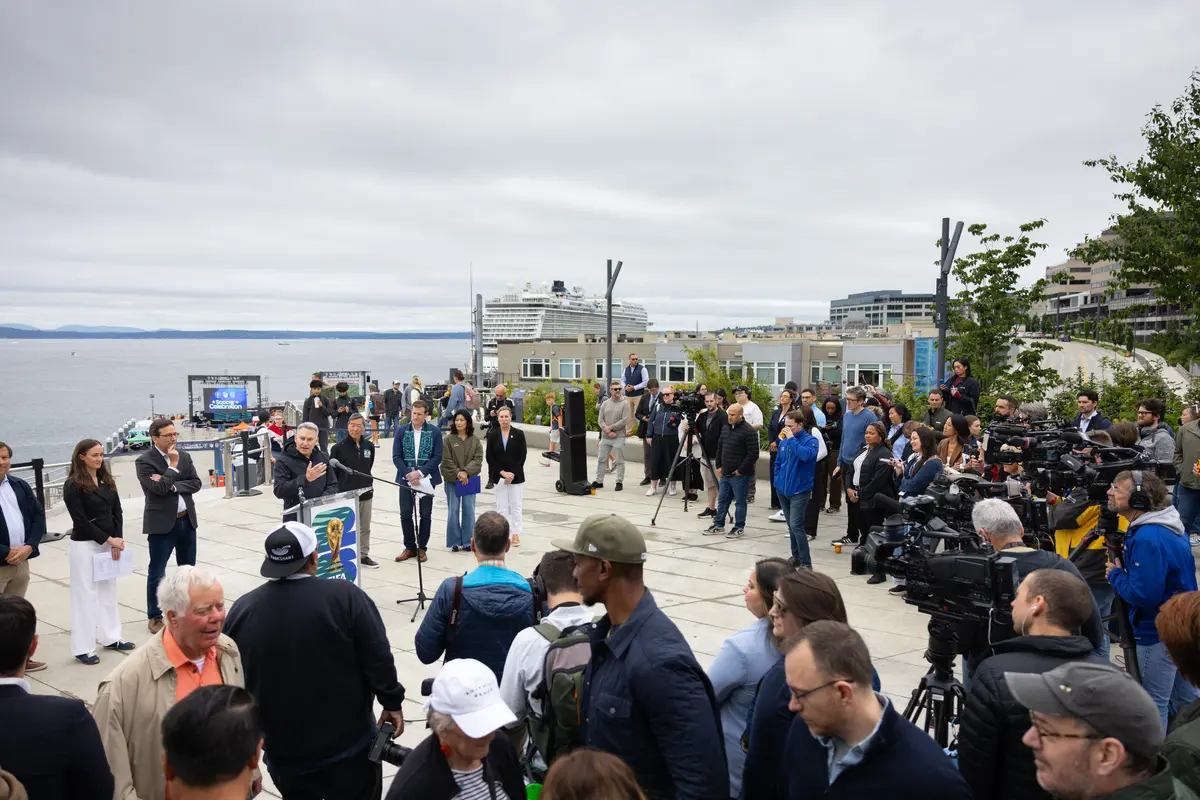 On the renovated Seattle waterfront overlook, Sound Transit CEO Dow Constantine speaks to a crowd of reporters and camera crews